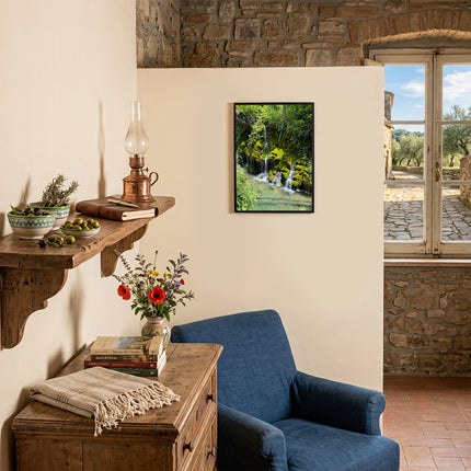 Quadro decorativo con stampa delle Cascate Capelli di Venere appeso nella parete di un accogliente angolo lettura con poltrona blu.