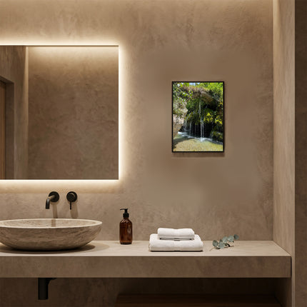 Stampa naturalistica con cornice in legno noce appesa sopra il lavabo in un bagno moderno di un hotel.